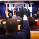 A reporter wearing a latex glove raises his hand to ask U.S. President Donald Trump a question during Coronavirus briefing at the White House on March 16, 2020, in Washington, DC.